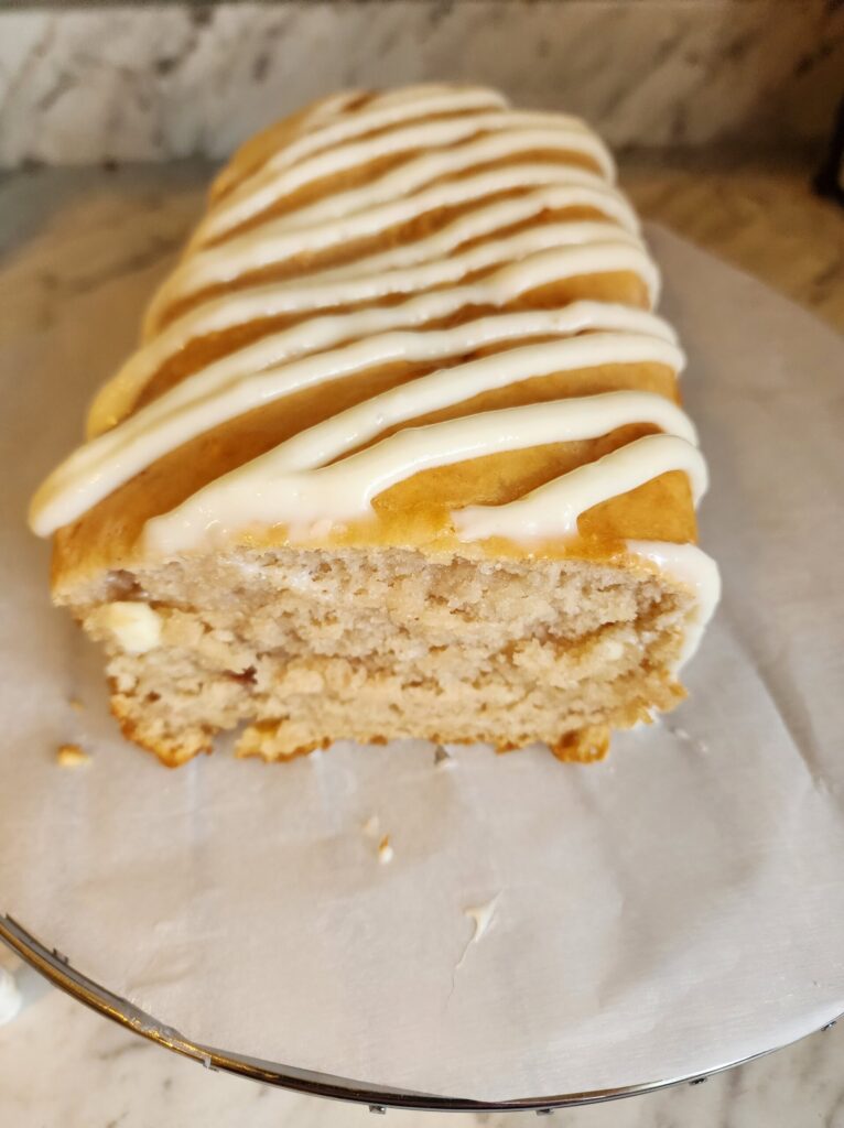 Strawberry Ice Cream Bread with a cream cheese glaze on parchment paper